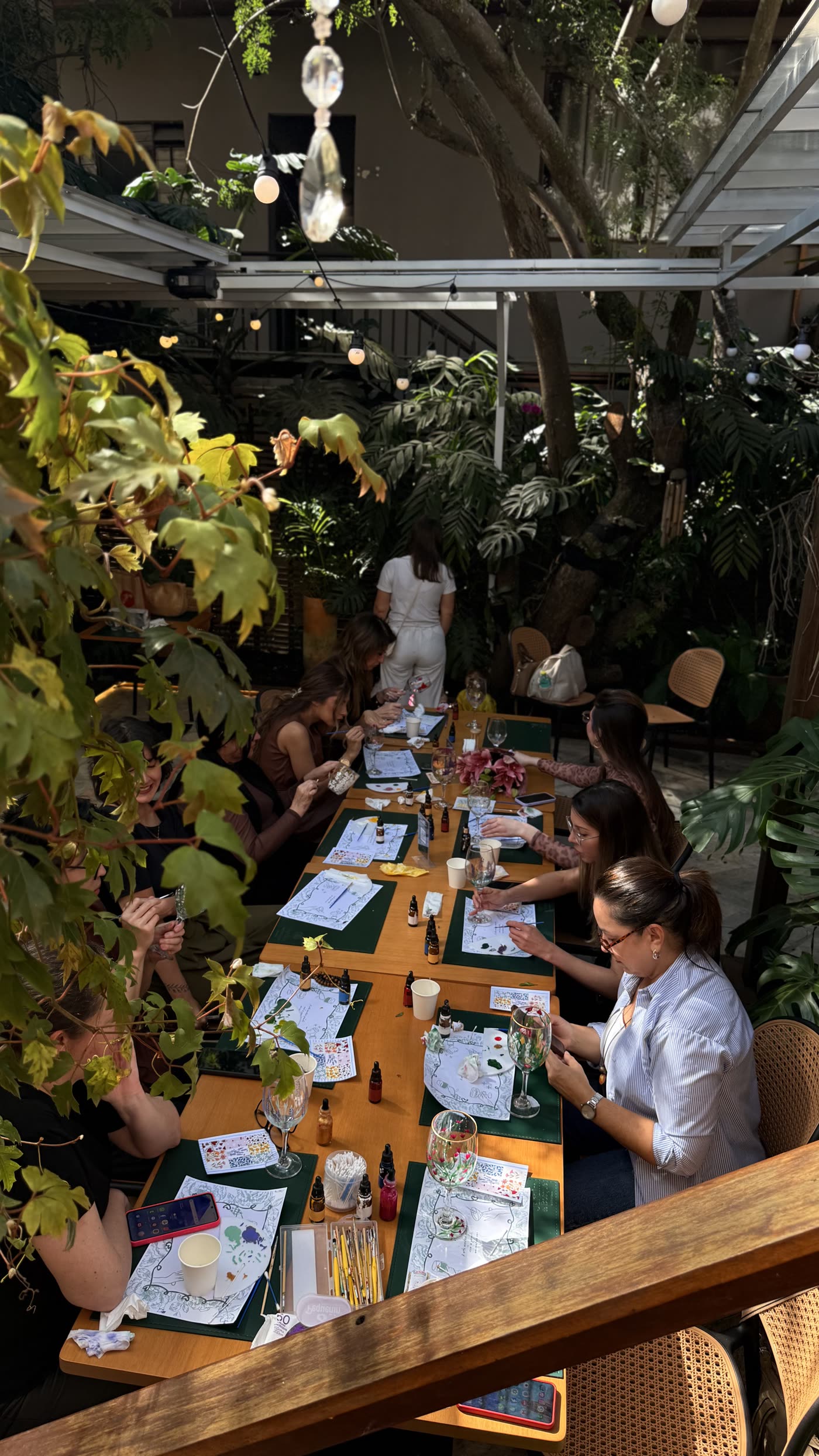 Mulheres reunidas em volta da mesa pintando taças num encontro da Rekintsu